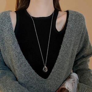 Silver interlocking rings pendant necklace worn with grey cardigan and black top