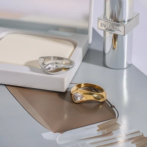 Macro detail of silver and gold layered rings featuring pear-cut stones and liquid metal design
