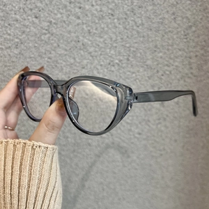 Detail von trendigen, durchscheinenden grauen Cat-Eye-Brillenfassungen für Damen in der Hand