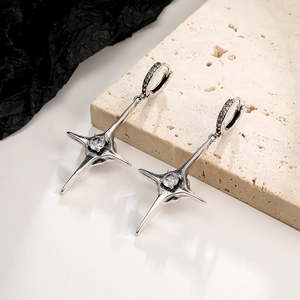 Close-up of vintage silver hoop earring featuring a star pendant with sparkling zircon stone