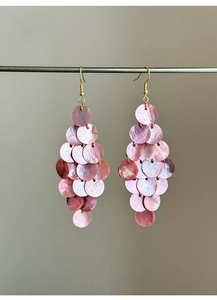 Detail of pink shell tassel drop earrings with tiered scale design on golden hooks