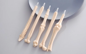 Detailed view of bone shaped ballpoint pens in five unique skeletal forms and beige color