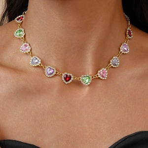 Gros plan de pendentifs en forme de cœur avec pierres colorées sur collier doré