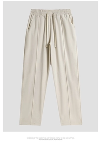 Detail of cream white wide-leg trousers showing elastic drawstring waist and vertical seam