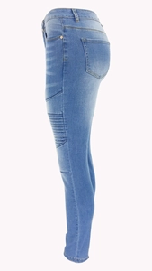 Detail of blue biker skinny jeans showing ripped knees and folded stitching texture