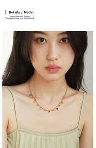Close-up of a gold-plated beaded necklace with seven colorful mini bean charms on a model