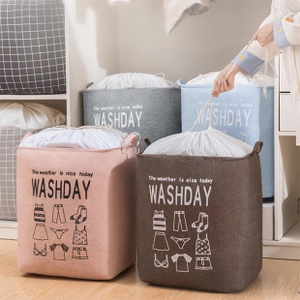 Detail of multi-color fabric laundry baskets with drawstring closure in home setting