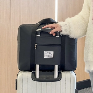 Large black travel bag with trolley sleeve attachment shown on a white suitcase