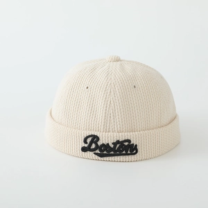 Détail du bonnet miki en velours côtelé crème avec broderie Bostons noire sur le bord