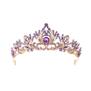 Macro detail of luxury baroque crown with purple rhinestones and golden alloy texture