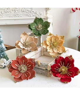 Detail of velvet Christmas flowers with golden glitter petals for holiday tree decoration