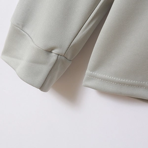 Close-up of grey polo shirt sleeve with breathable mesh texture and double stitching