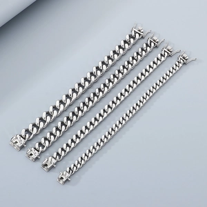 Macro view of silver cuban chain bracelets showing four different link widths and textures