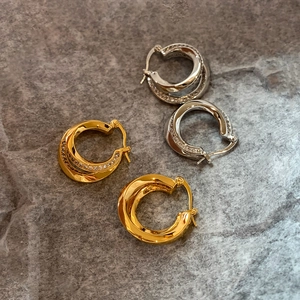 Double-layered twist hoop earrings with pavé zircons in gold and silver finish