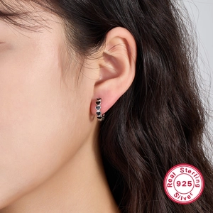 925 sterling silver hoop earrings featuring small black heart details on a female model
