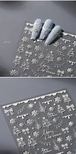 Dettaglio di adesivi per unghie 5D con fiocchi di neve bianchi e motivi natalizi