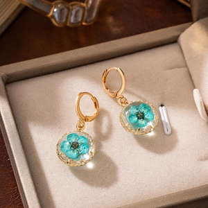 Elegant gold drop earrings with blue dried flowers encased in clear glass balls
