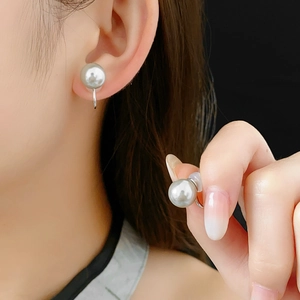 Close-up of 10mm grey pearl ear cuffs with silver clip-on design on black background