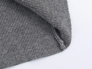 Detailed macro shot of grey ribbed knit fabric showing high-quality stitching and texture