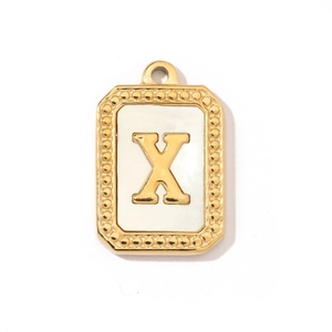 Macro detail of golden rectangular pendant with shell inlay and embossed letter X