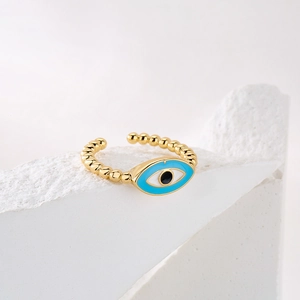 Macro detail of 18K gold plated evil eye ring showing beaded texture and blue enamel inlay