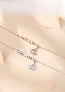 Close-up of S925 silver and rose gold ginkgo leaf bracelets with zircon inlay and beads