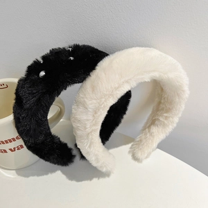 Close-up of plush faux mink fur headbands in black with pearls and solid white