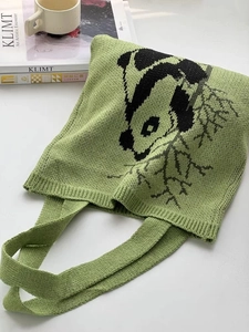 Detail of green knitted tote bag featuring a cute cartoon panda and bamboo pattern