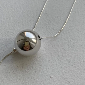 Minimalist 925 sterling silver ball pendant necklace on a textured grey background