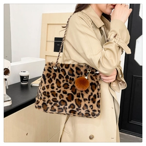 Detail of leopard print faux fur shoulder bag with gold chain strap and pompom charm