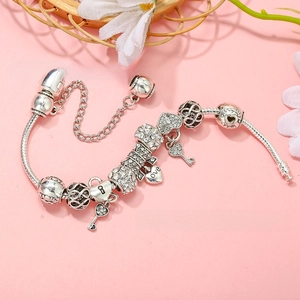 Detail of silver snake chain bracelet with heart charms and crystal beads