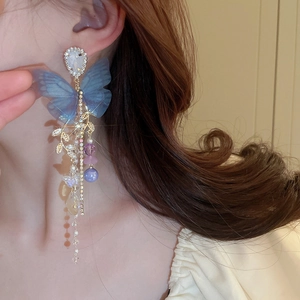 Elegant blue butterfly tassel earrings with pearls and rhinestones on model