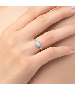 Detailed macro view of an S925 silver Evil Eye ring with blue and white stones on finger