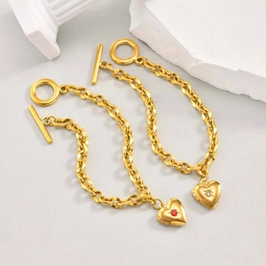Bracciale a catena con medaglione a cuore dorato, chiusura OT e gemma rossa brillante