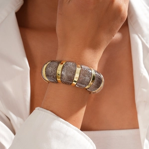 Close-up of bohemian acrylic chunky bracelet with glitter gray beads and gold metal spacers
