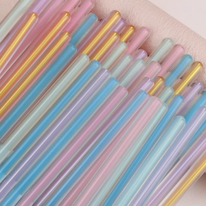 Multi-color pearlescent hot glue sticks set for DIY crafts on a soft pink background
