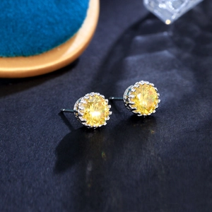 Macro shot of 8mm yellow cubic zirconia earrings in a silver crown-shaped setting