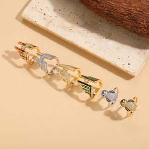 Detailed view of V-shaped zircon rings and penguin band rings on natural stone props