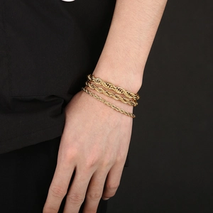 Three gold layered twist rope chains for men and women on a wrist in titanium steel
