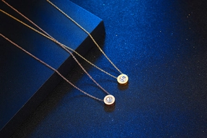 Macro shot of titanium steel necklaces with round solitaire pendants and side engravings