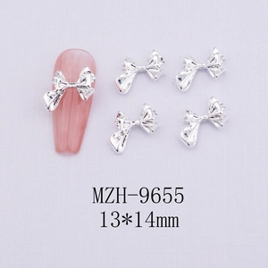 Macro shot of silver metal bow nail charms with 13x14mm dimensions for DIY nail art