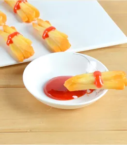 Detailed view of realistic PVC French fries with ketchup on a white ceramic plate
