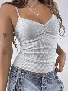 Détail du débardeur blanc Y2K avec des paillettes brillantes, de la dentelle et du tissu côtelé