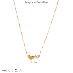 Gold stainless steel cross necklace with zircon heart pendant on white background