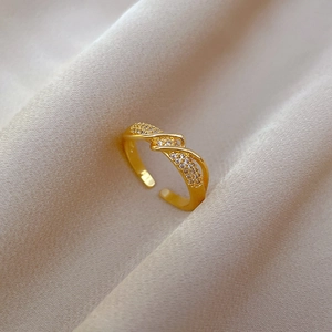Macro view of gold plated twisted open ring featuring micro-pave cubic zirconia accents