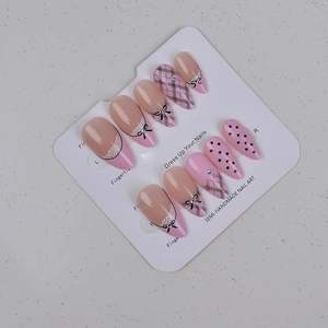 Detailansicht der rosa Mandel-Nägel mit Schleife, Gittermuster und Spitzen-Design