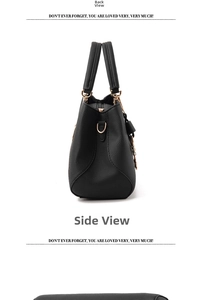 Side view of black pebble leather handbag with gold metal rings and sturdy double handles