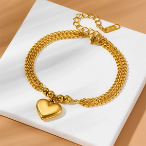Double-layered gold stainless steel bracelet featuring heart pendants on stone pedestal