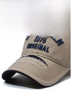 Detail of khaki distressed baseball cap with blue 1975 ORIGINAL embroidery and frayed brim