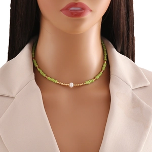 Bohemian seed bead necklace with white pearl on a model wearing a beige blazer